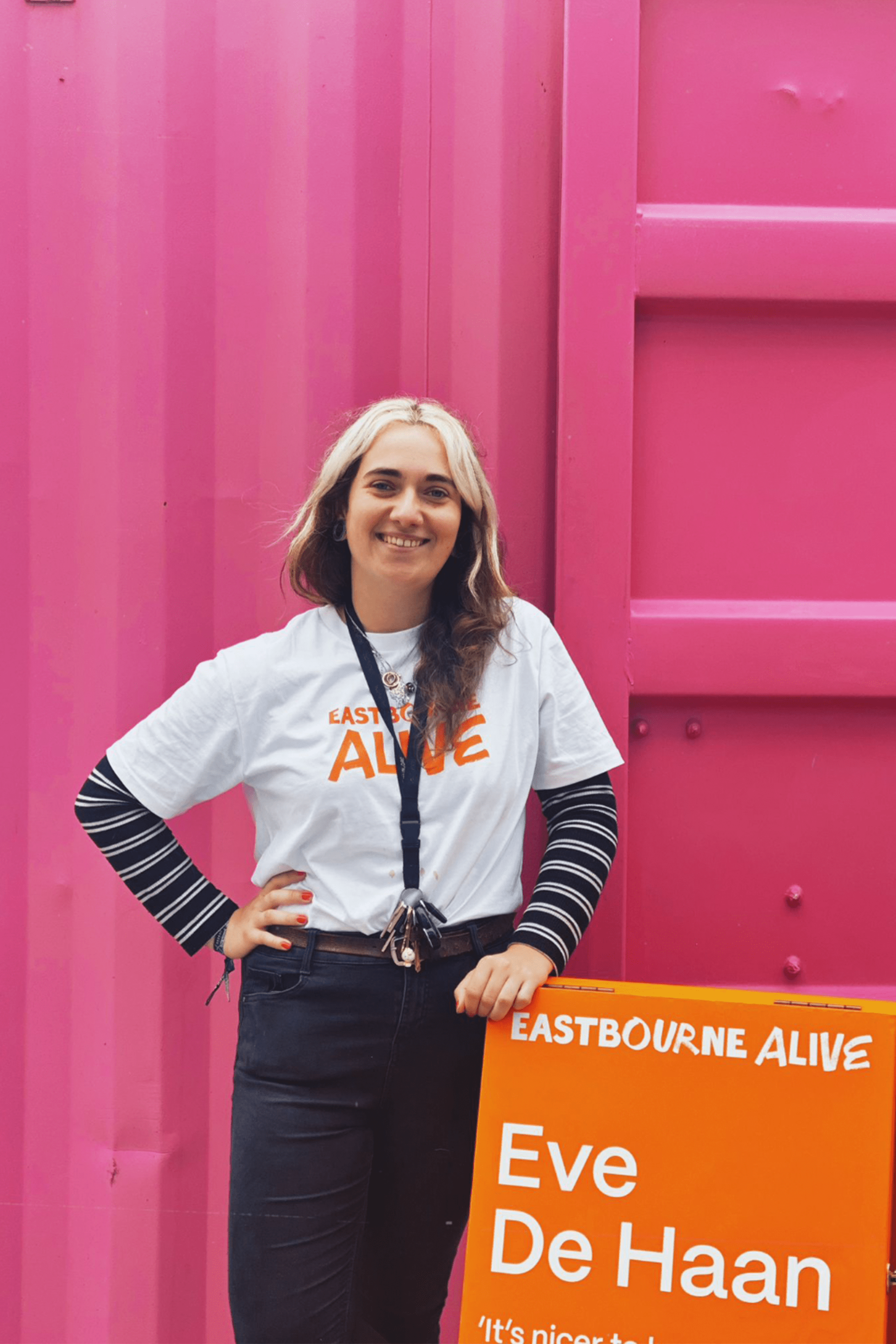 A volunteer stands in front of Even De Hann's 'Healing Garden' wearing an Eastbourne Alive T-shirt